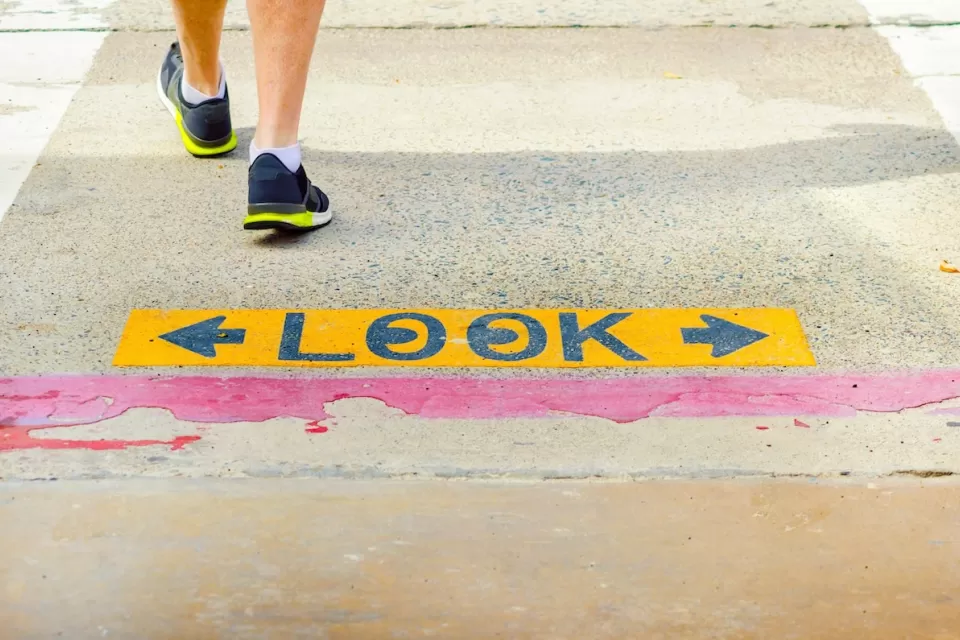 Close-up of "LOOK" sign on sidewalk with one pedestrian walking away.